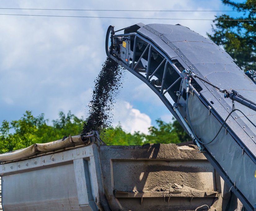 a slinger loads aggregate into a truck